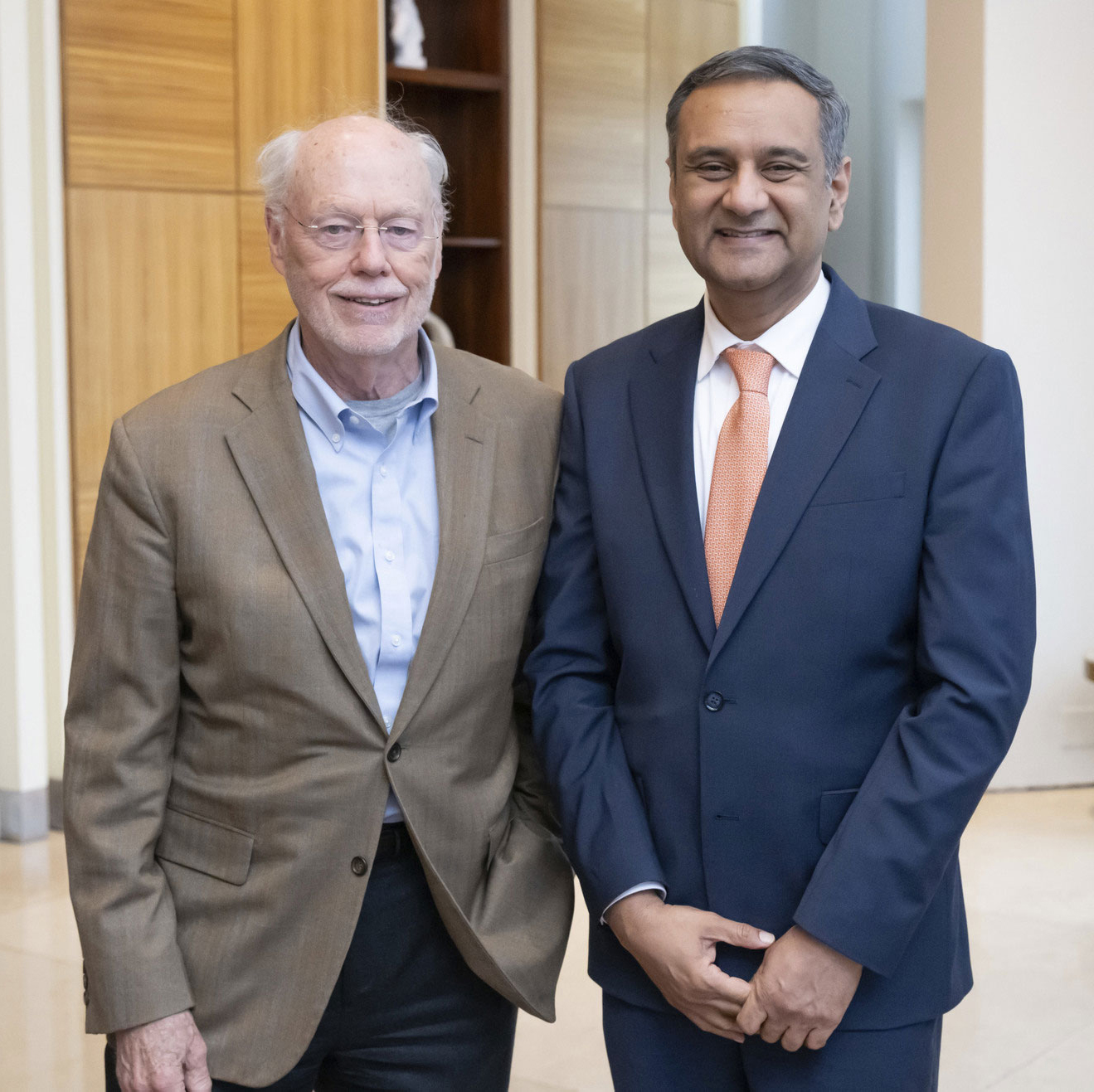 Phillip Sharp and bioengineering professor Rohit Bhargava stand in front of a wooden background, smiling