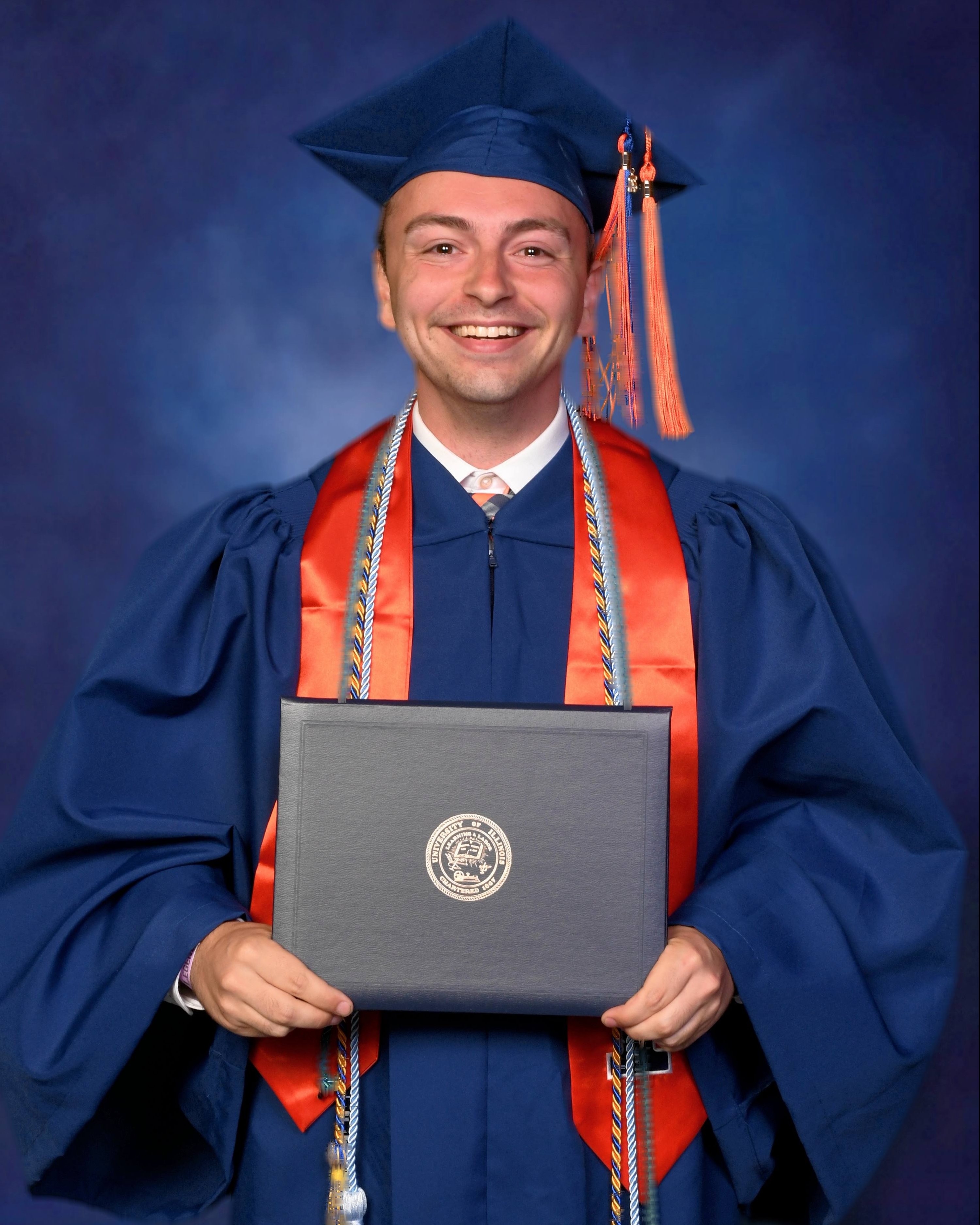 A bioengineering graduate smiles at the camera in a cap and gown.