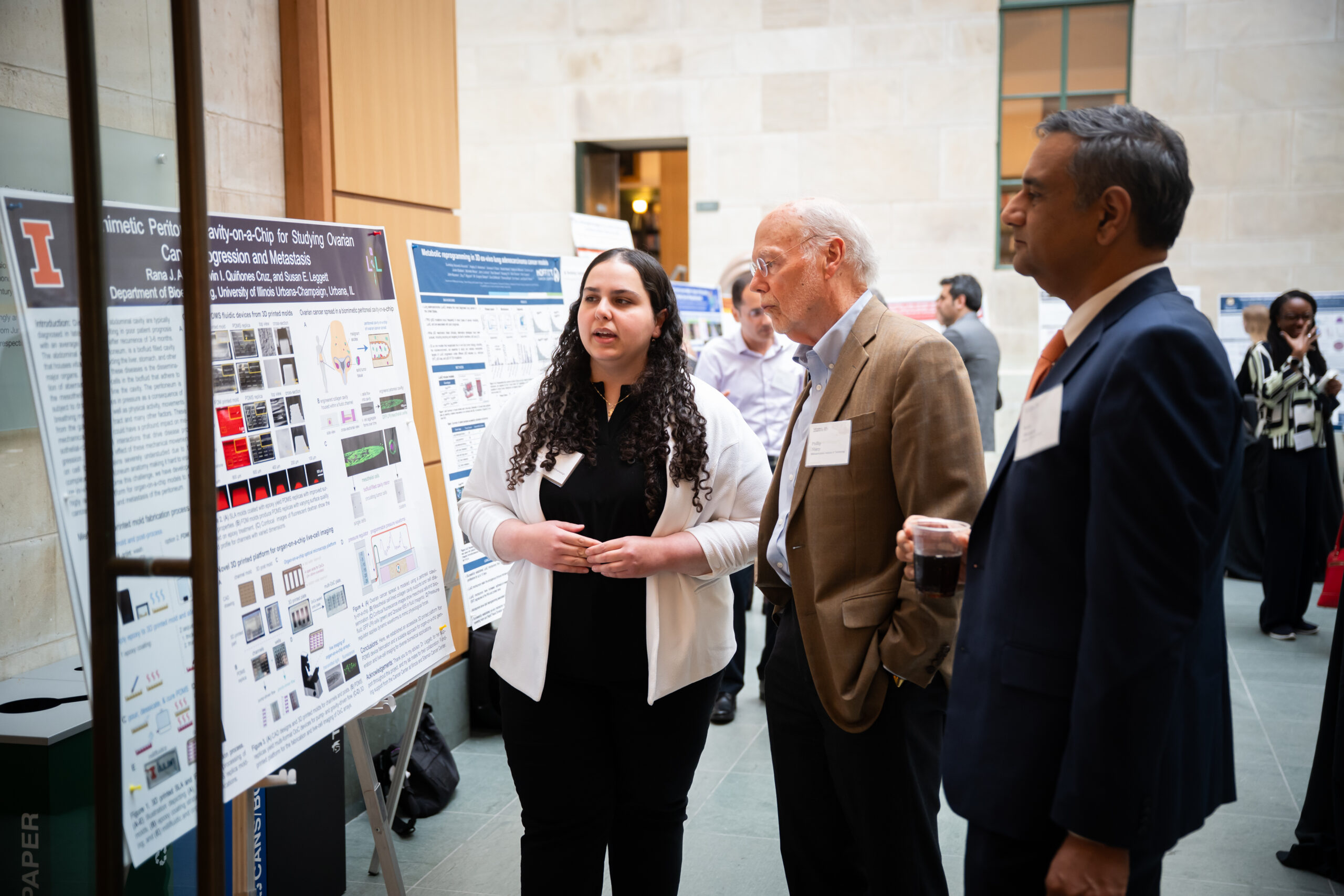&amp;lt;em&amp;gt;Rana Abbed presents her research to Nobel Laureate Phillip Sharp and Cancer Center at Illinois Director Rohit Bhargava.&amp;lt;/em&amp;gt;