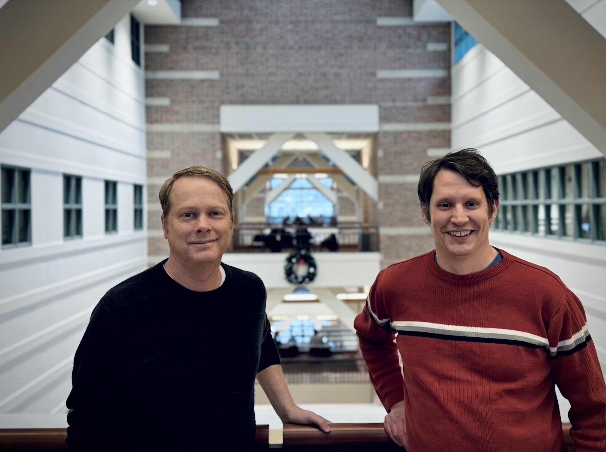 Two men on a bridge inside the Beckman Institute.