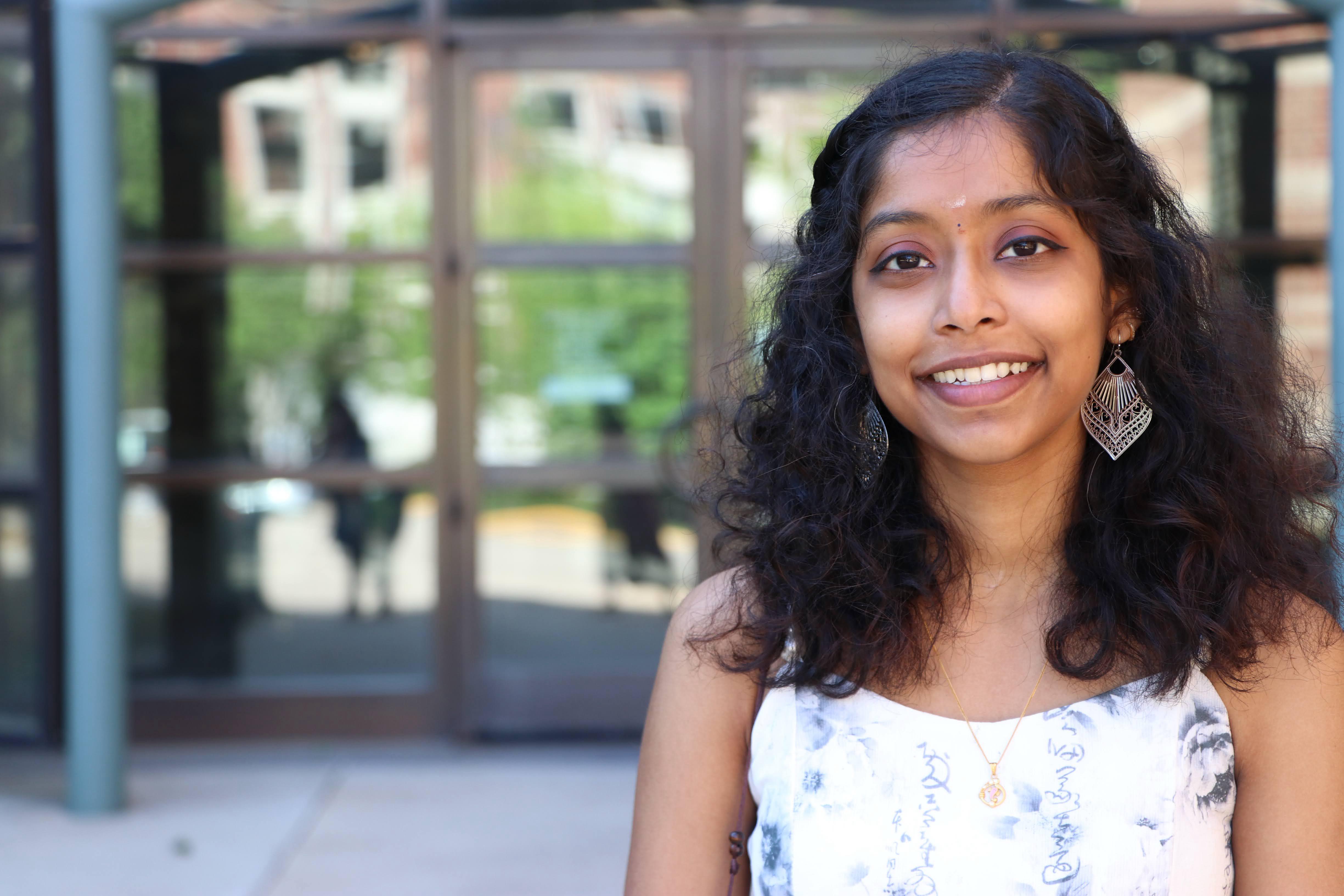 Revathi Manoharaan smiles at the camera.