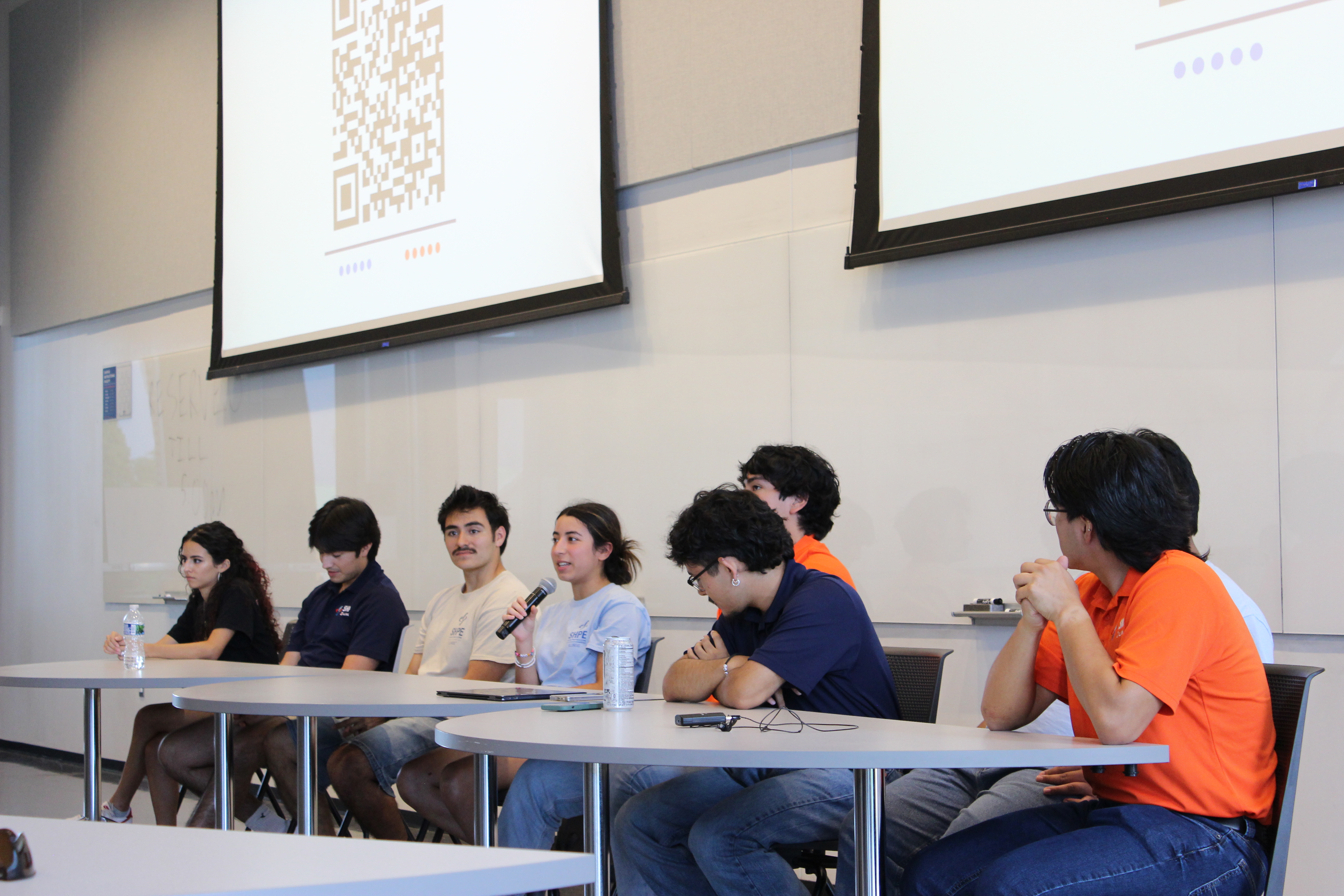 A group of students sit at a pannel, facing out