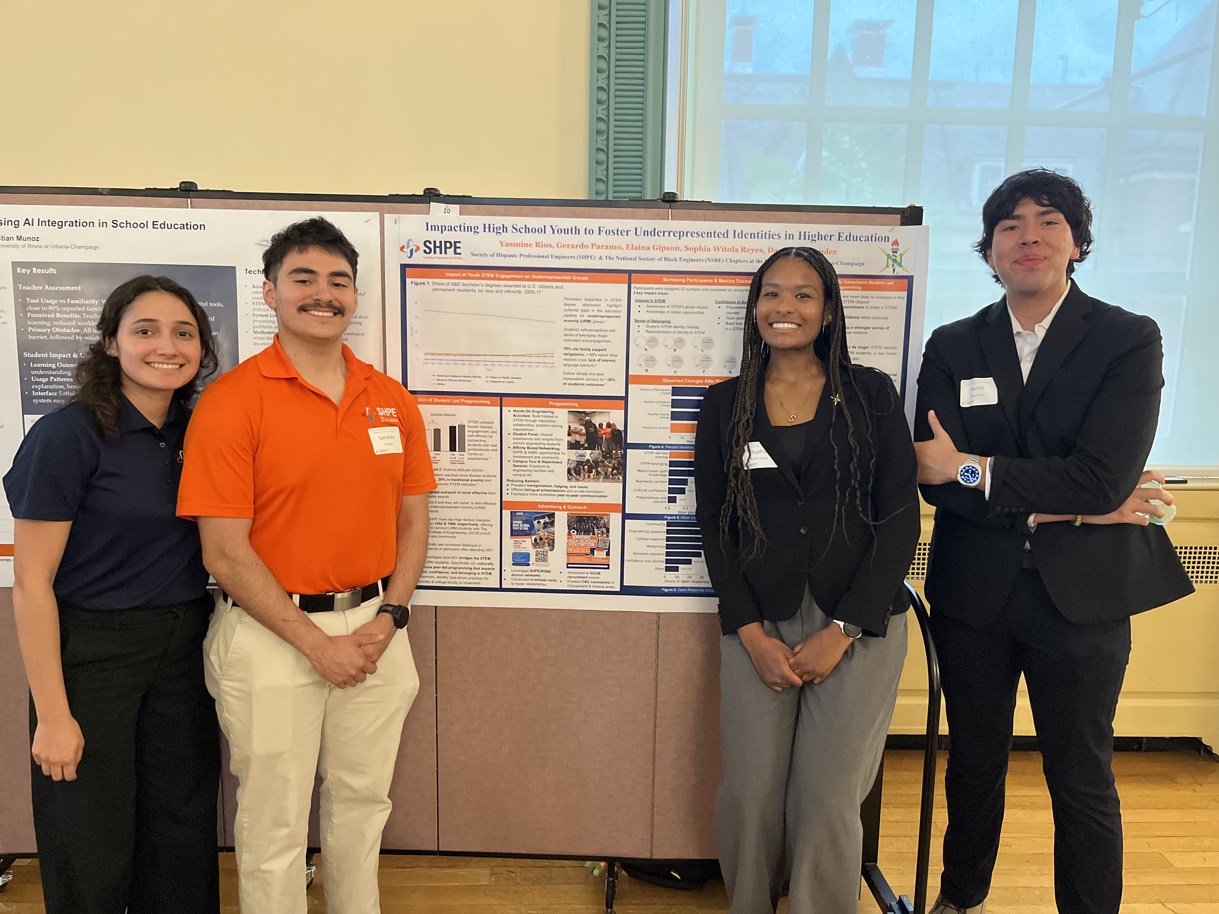 Four students stand in front of their research poster