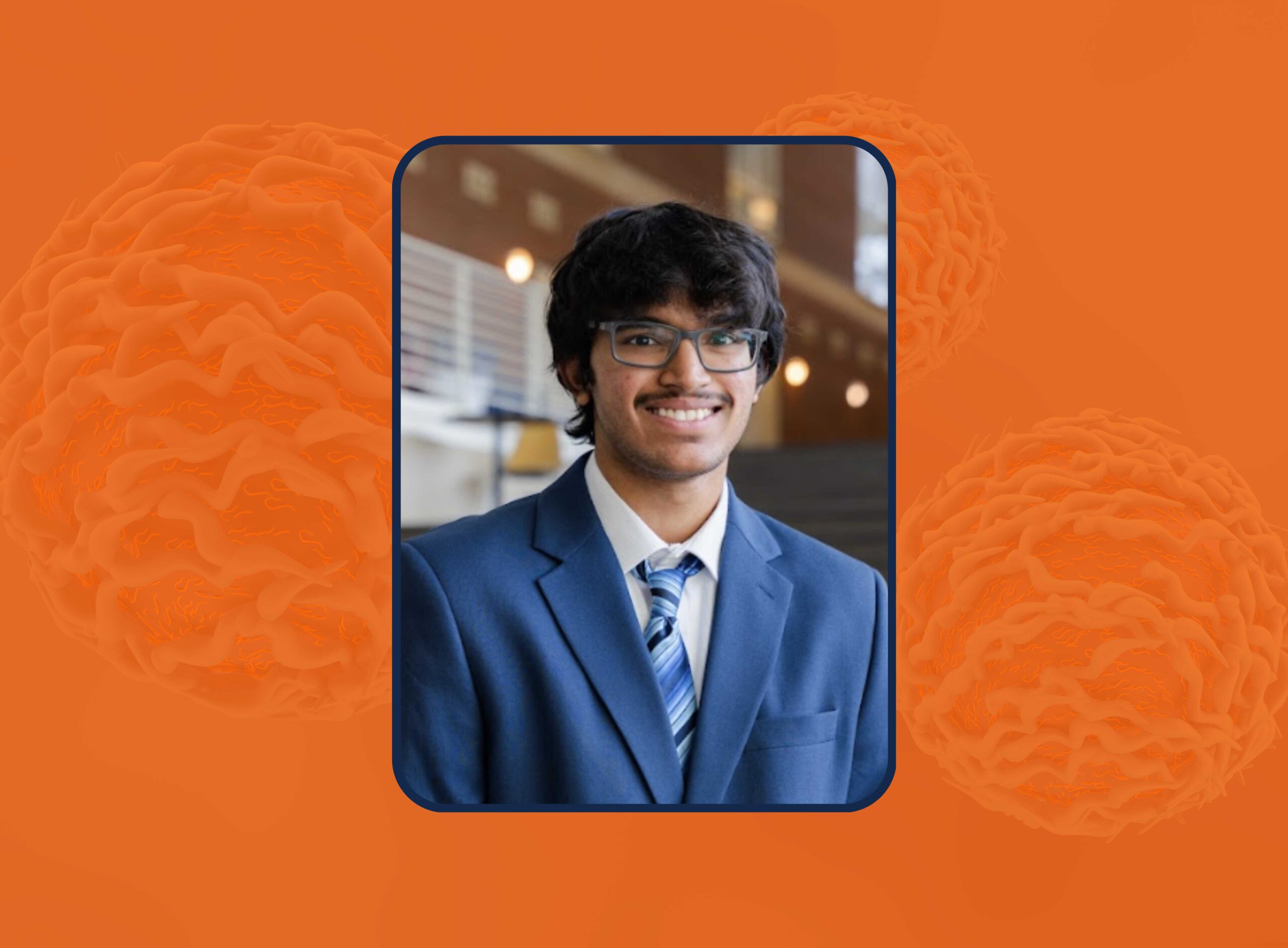 A student wearing a suit smiles at the camera