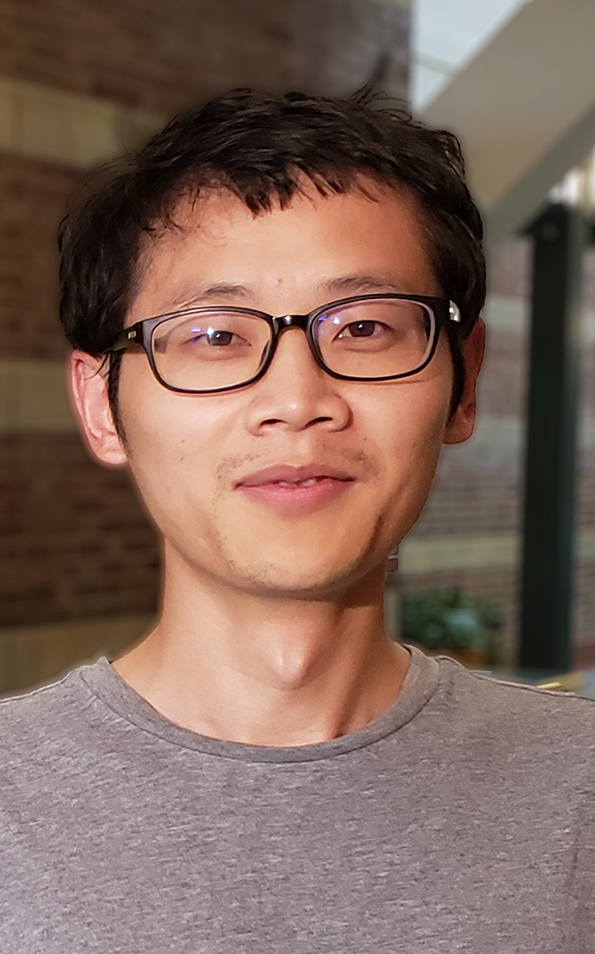 A man with a brown shirt and black glasses