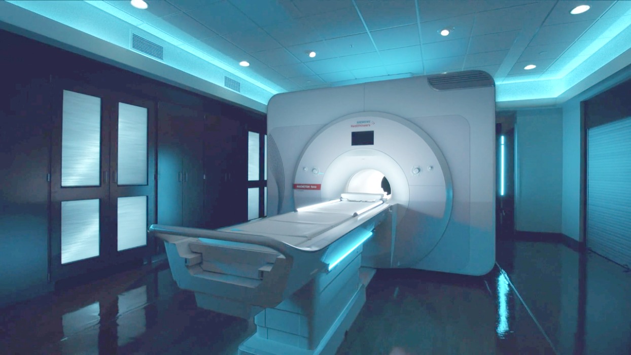 A large MRI machine in a blue-lit room