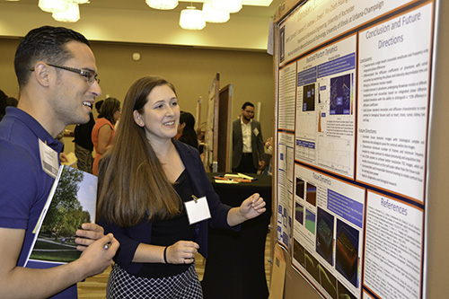 male and female student in front of a poster
