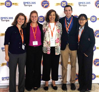 photo of students in front of conference banner with professor marjanovic in the center