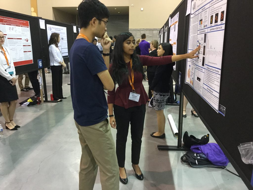 female student explains research poster