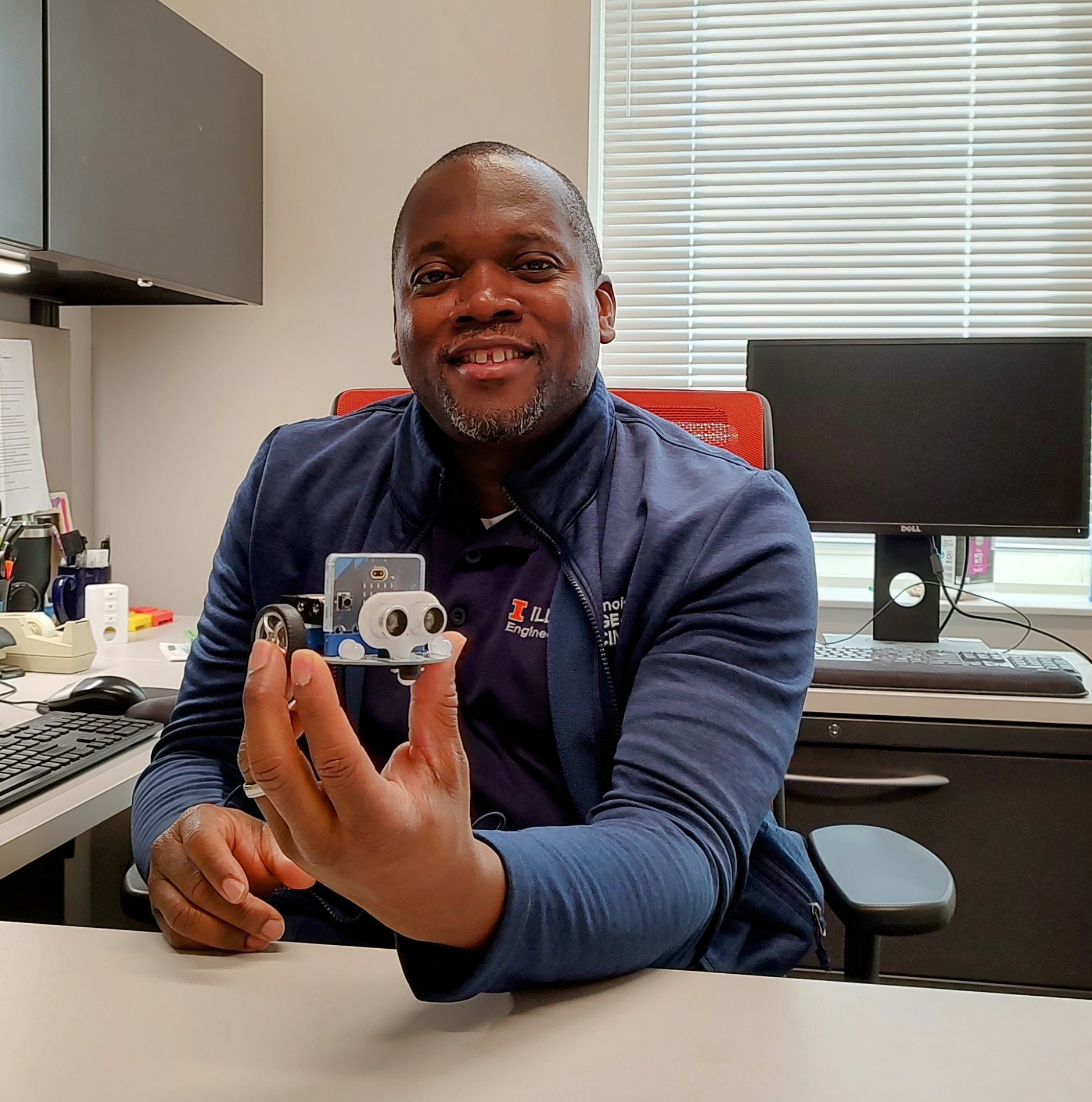 Professor Bradley displays a programmable CuteBot microbit toy car.